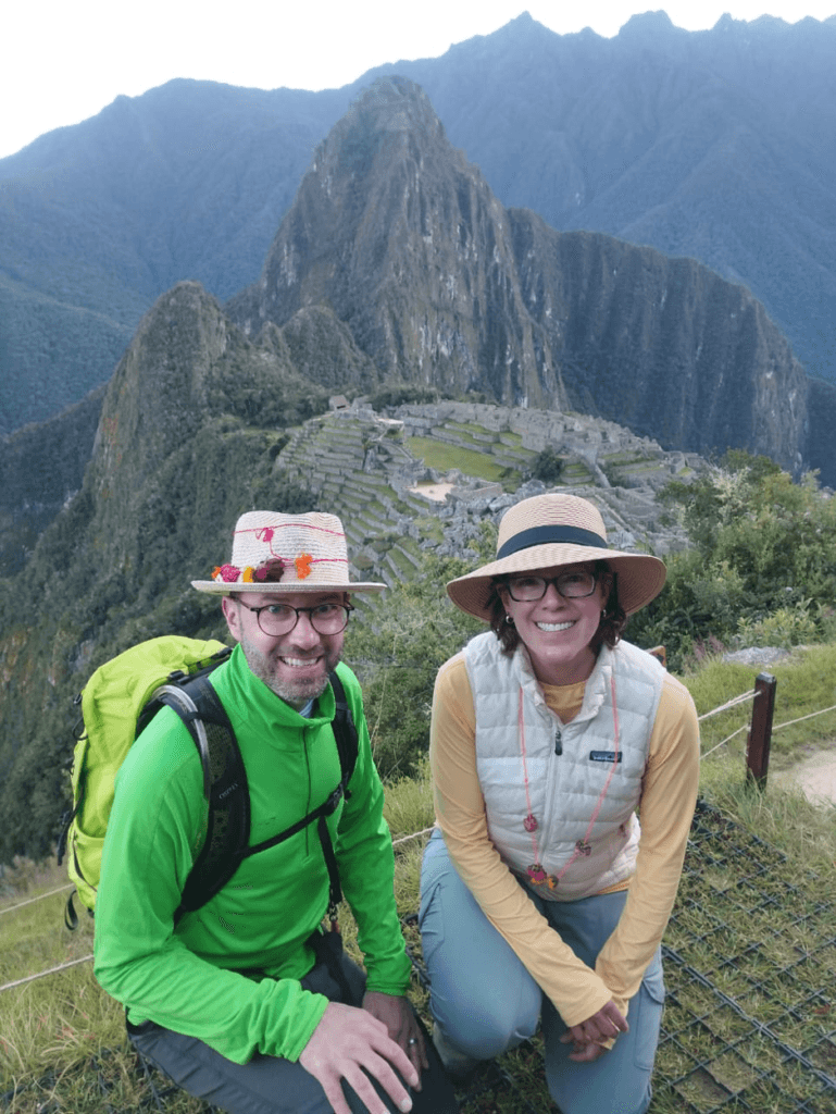A photo of two tourists with Machu Picchu in the background.