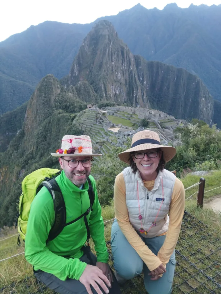 Una foto de dos turistas con Machu Picchu de fondo.
