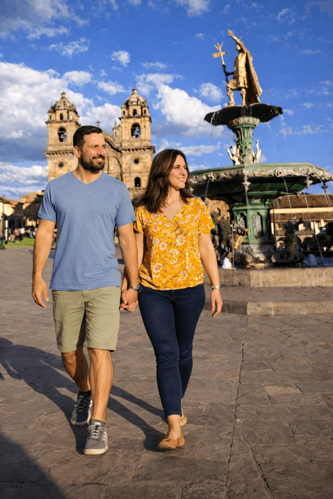 A photo of a couple walking through Cusco's Main Square.