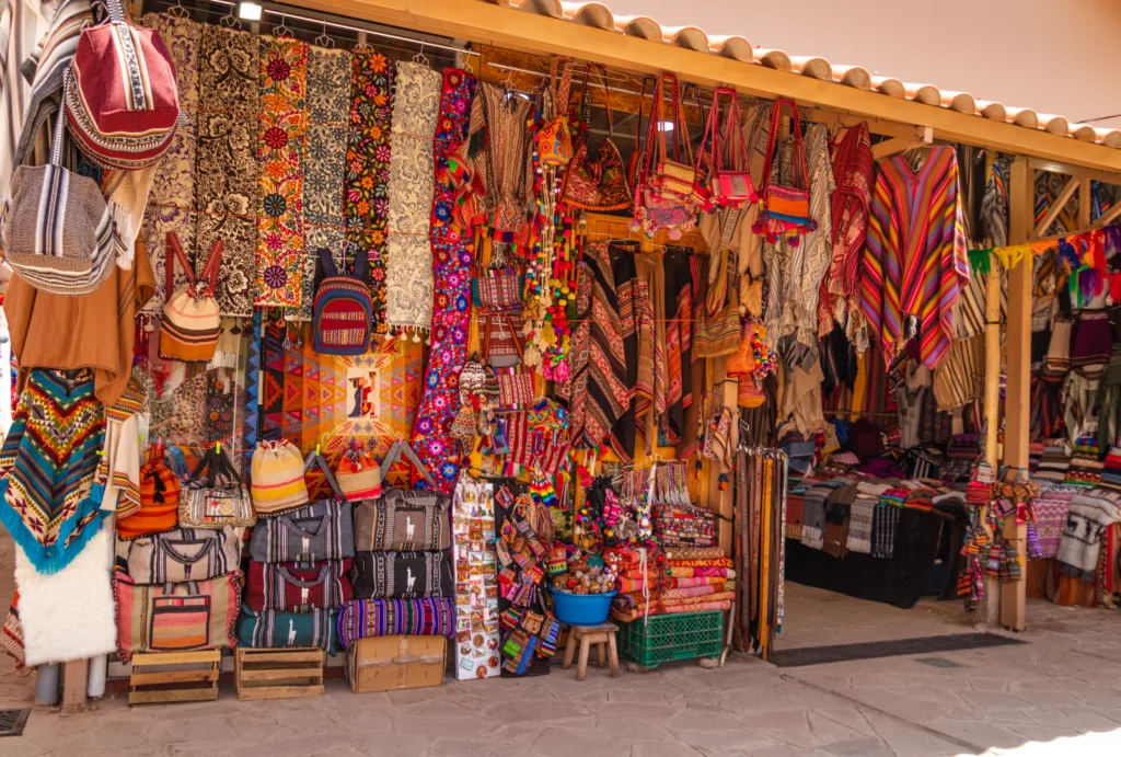 Fotografía de un puesto en un mercado de Cusco que ofrece textiles tradicionales.