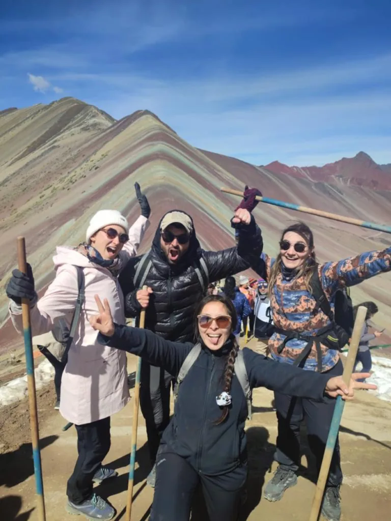 Una foto de turistas con la Montaña Arcoíris de fondo.